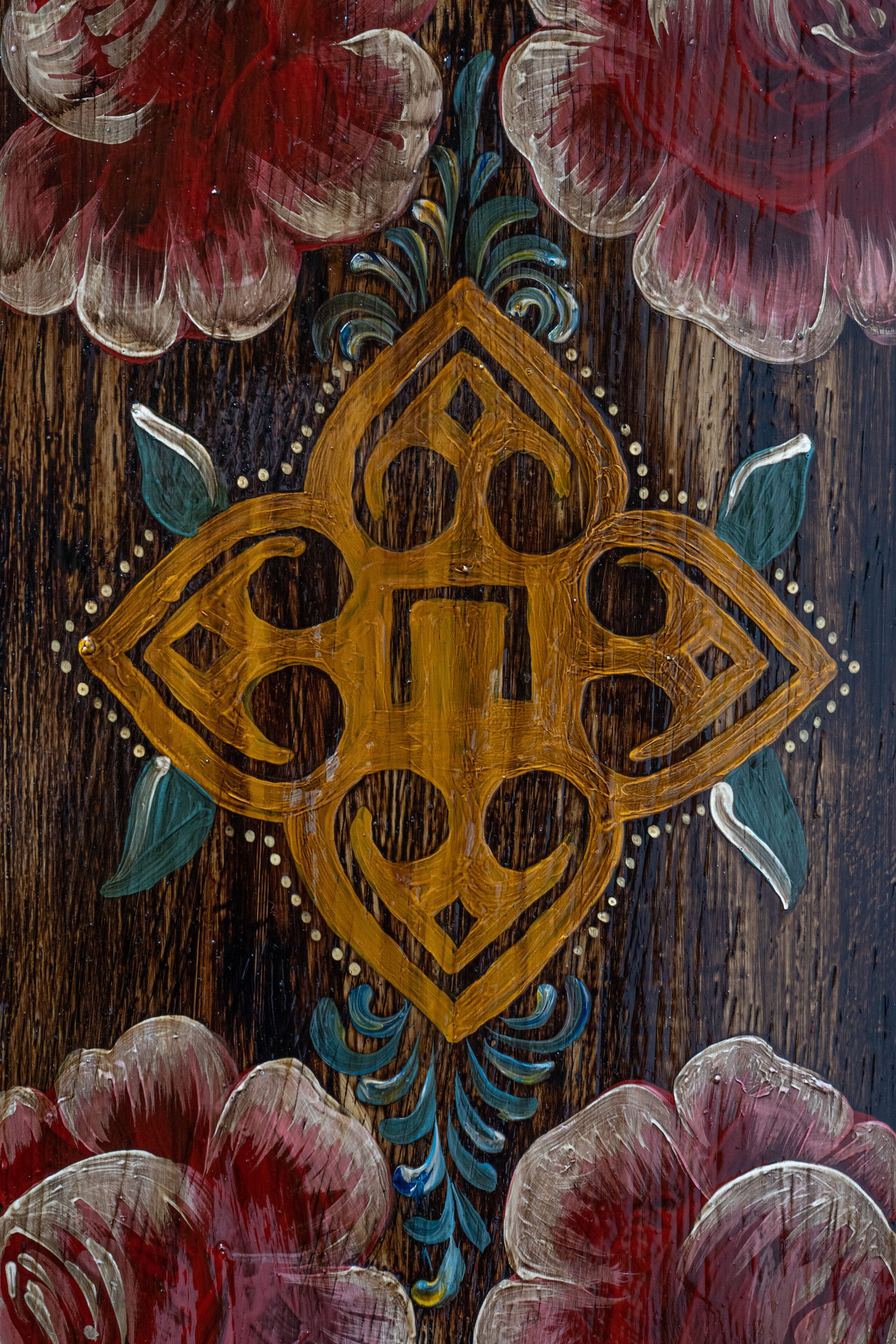 A wooden surface with a decorative emblem and floral patterns.