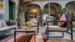 Un interior acogedor con un arco de piedra, un sofá, una silla y una mesa con un jarrón de flores.