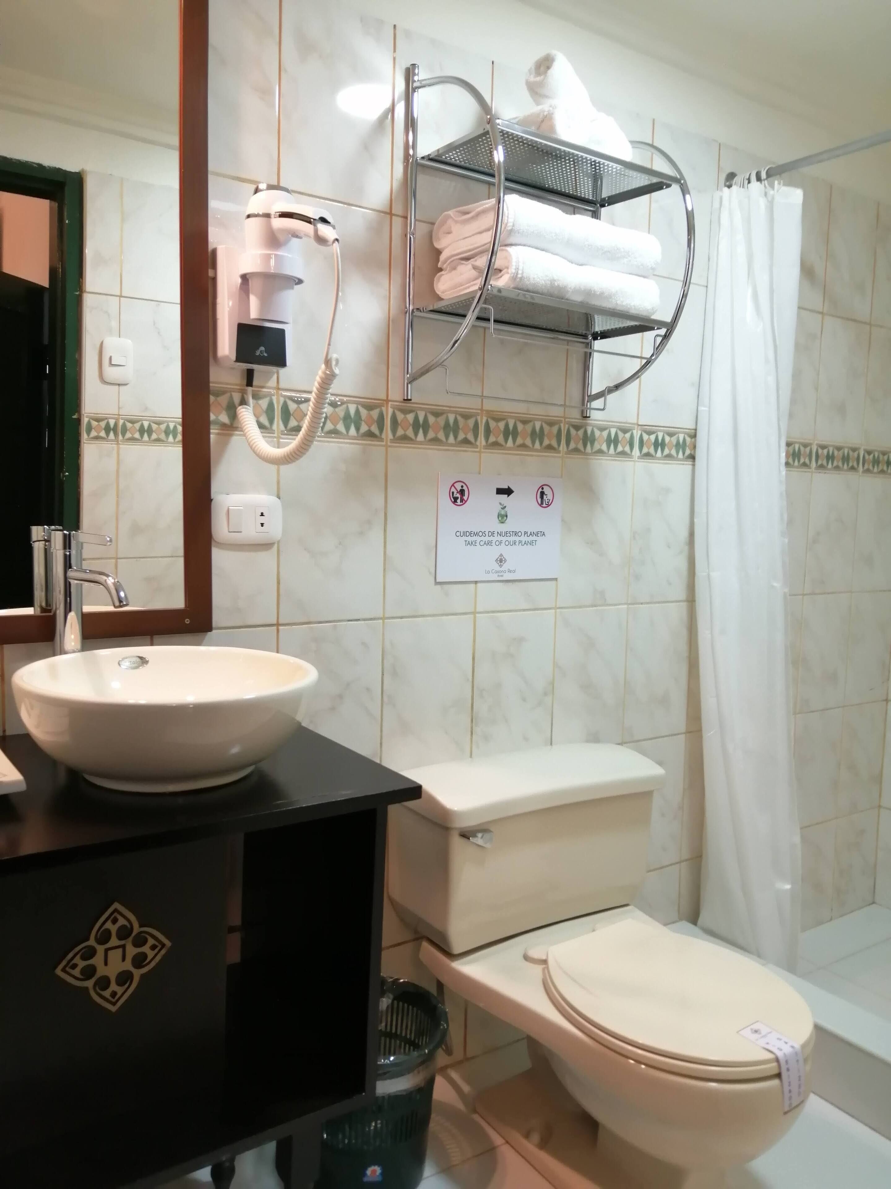 A bathroom with a sink, toilet, and shower curtain.