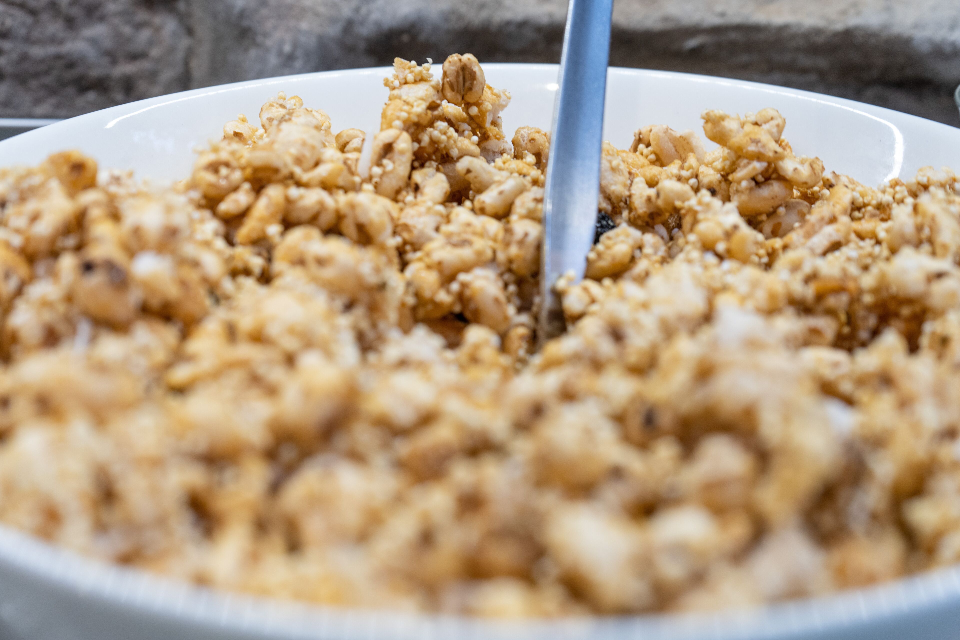 Un plato blanco con granola y frutos secos.