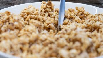 Un plato blanco con granola y frutos secos.