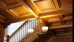 A grand staircase with wooden railings and a chandelier. - White Lace Inn (Sturgeon Bay)