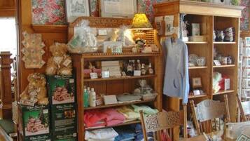 A cozy boutique with wooden shelves displaying various items like teddy bears, folded clothes, and decorative boxes.