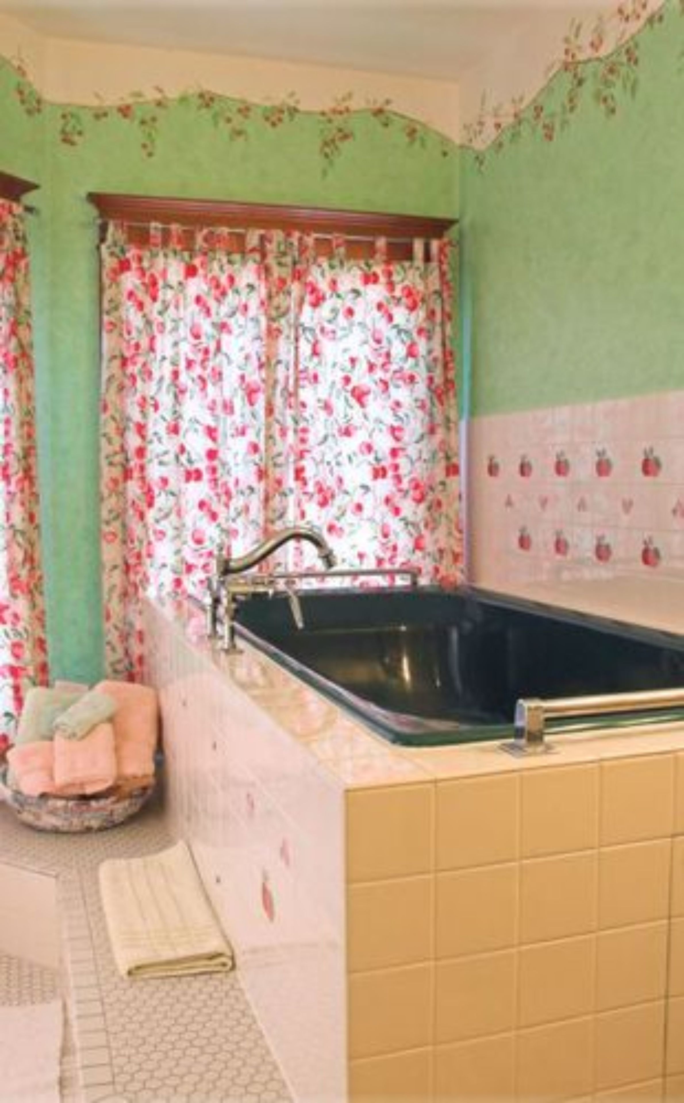A kitchen with a sink, a window with floral curtains, and a tiled backsplash.