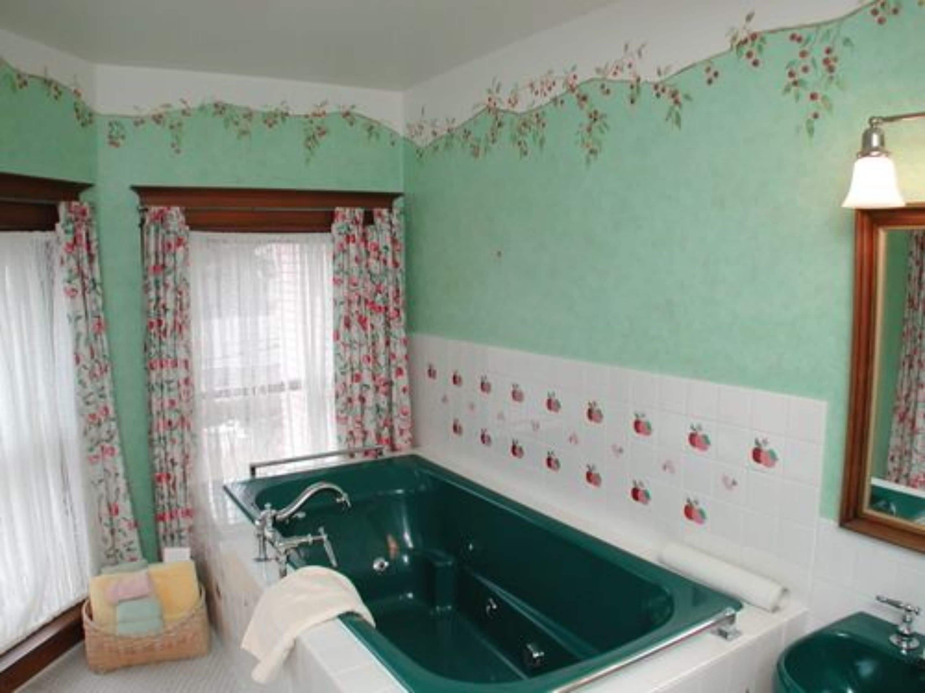 Une salle de bain avec une baignoire verte, un lavabo et un miroir.