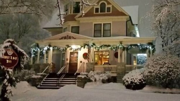 A two-story house with a porch, steps, and a sign that reads "White Lake Inn". - White Lace Inn (Sturgeon Bay)