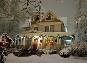 A two-story house with a porch, steps, and a sign that reads "White Lake Inn".