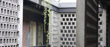 A building with a brick facade, a metal gate, and a concrete structure with square openings.
