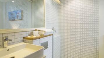 Une salle de bain moderne avec un lavabo blanc, un miroir et des toilettes.