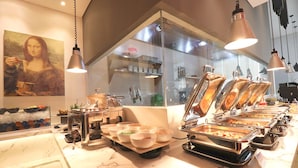 Un buffet composé de plusieurs présentoirs, d’un comptoir en marbre et d’un tableau représentant la Joconde accroché au mur.