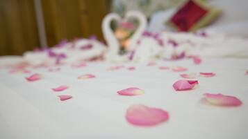 A bed with rose petals and a heart-shaped decoration.