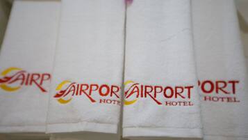 A set of white towels with the text "Airport Hotel" printed on them.