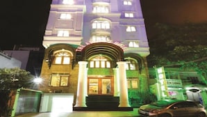 A hotel with a classic architectural style, featuring a central entrance with columns, multiple floors, and illuminated windows. - The Airport Hotel (Ho Chi Minh City)
