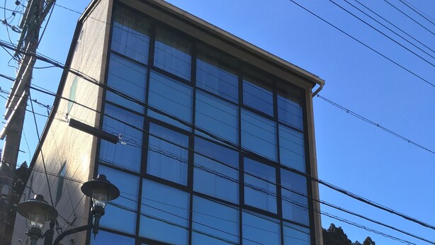 En moderne bygning med en glasfacade, en Coca-Cola automt og et skilt for Geroball Hostel.