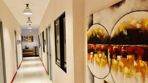 Pasillo de hotel largo, con puertas y luces en el techo.