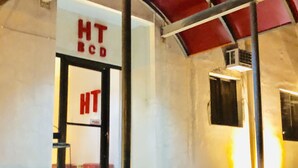 Entrada de hotel con un cartel que dice "HT BCD" y un botón pulsador.