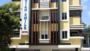 A multi-story hotel with a modern facade, balconies, and a flag on top. - Asian Smile Hotel (Yangon)