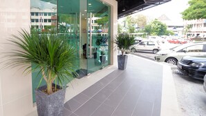 A modern building with large glass windows and a tiled entrance area. There are potted plants in front of the entrance. - Hotel Mezzo (Kuala Lumpur)