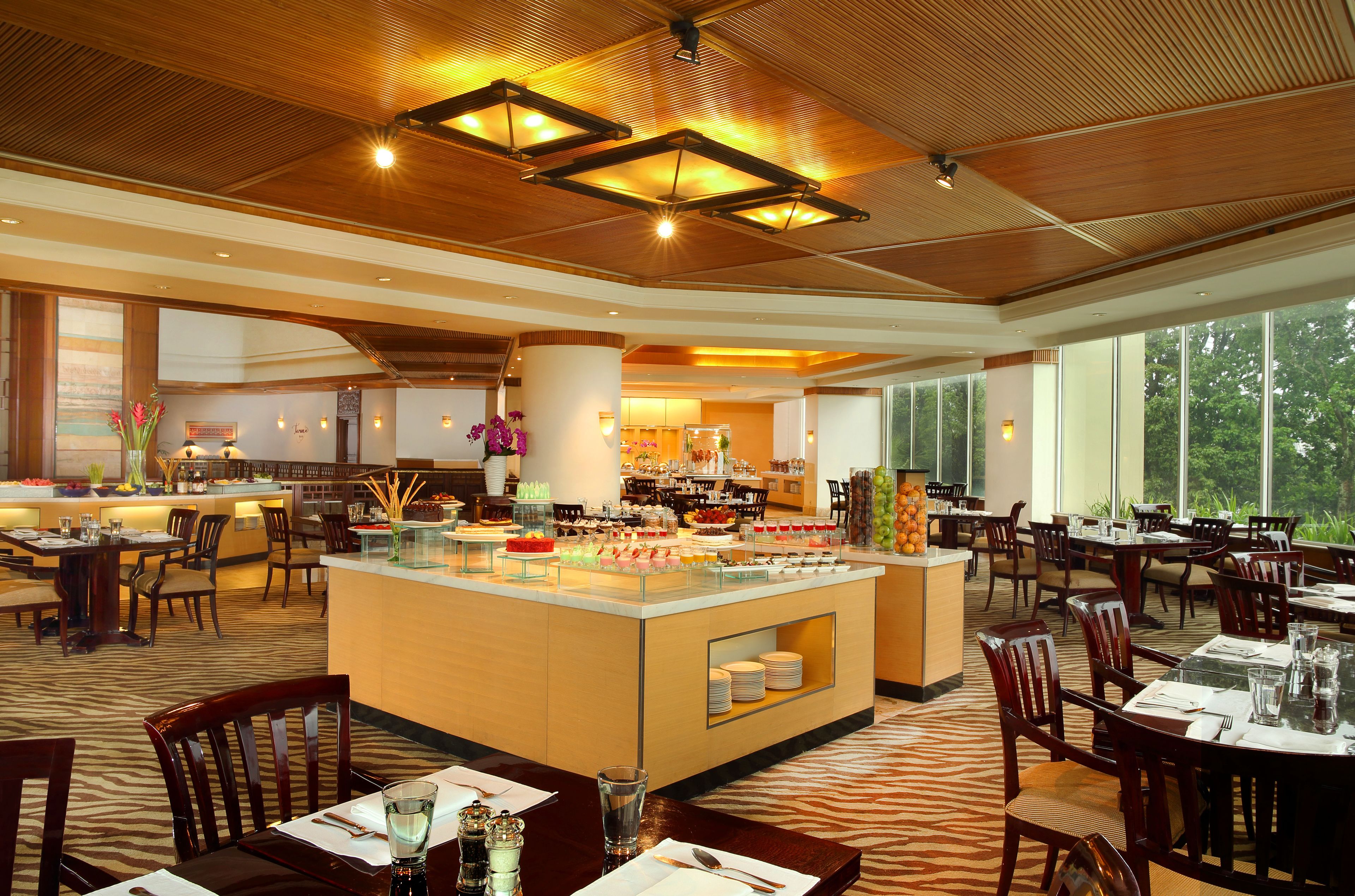 A spacious restaurant with a central bar area, multiple dining tables, and chairs.