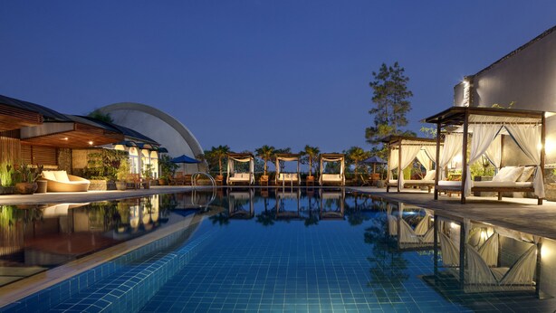 A pool area with lounge chairs and a covered seating area. - Aryaduta Bandung (Bandung)