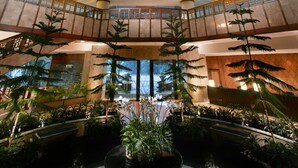 A multi-level atrium with a central circular water feature surrounded by potted plants. - Aryaduta Bandung (Bandung)