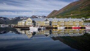 Un edificio junto al agua con numerosas ventanas y un muelle con barcos.