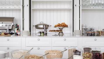 A buffet setup with various food items and glassware.