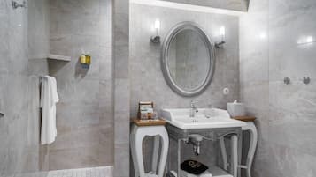 Un baño moderno con un espejo grande, un lavabo y una zona de ducha.
