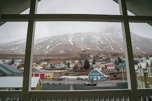 A view of a town with buildings and a mountain in the background.