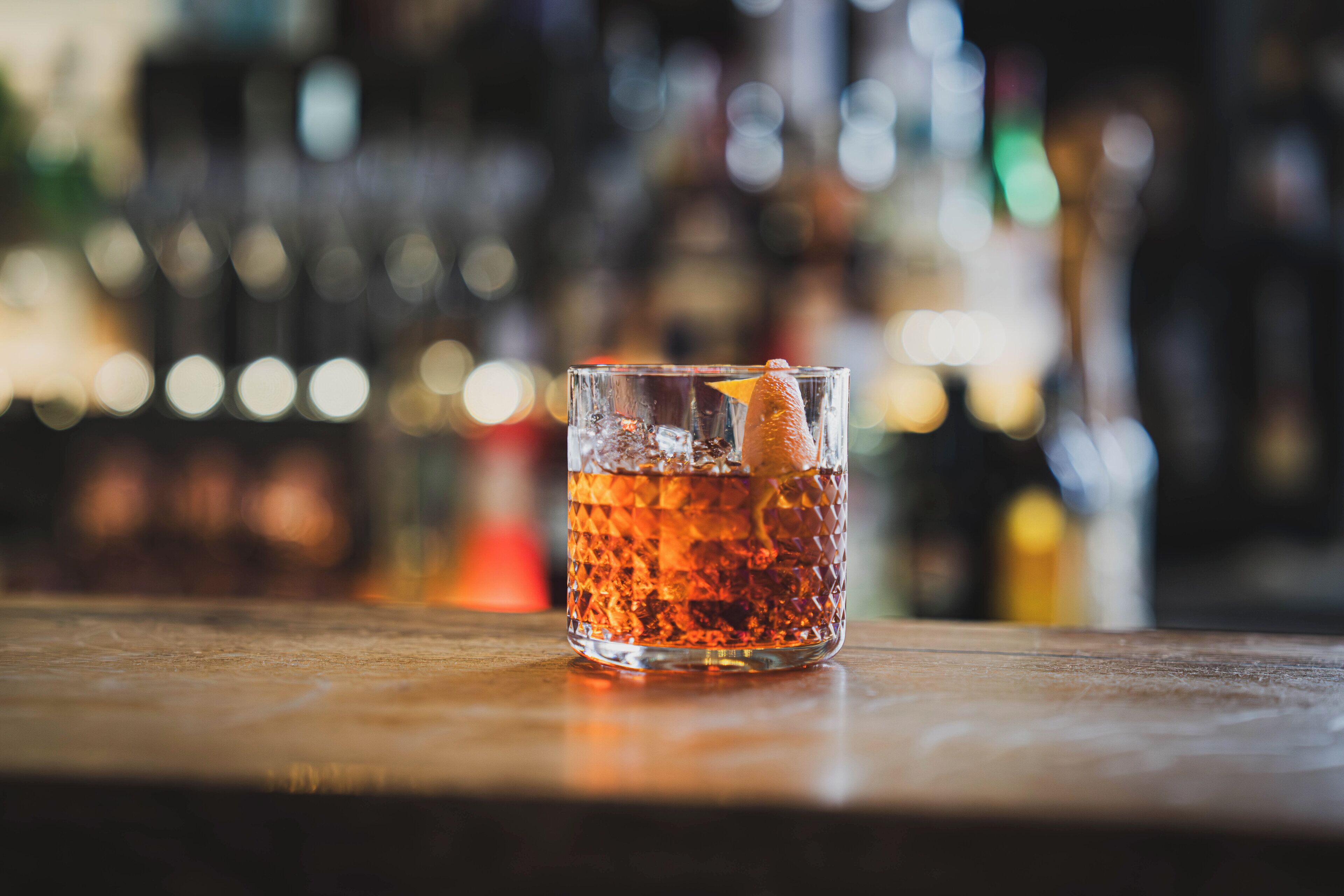 A clear glass with a beverage on a wooden surface.