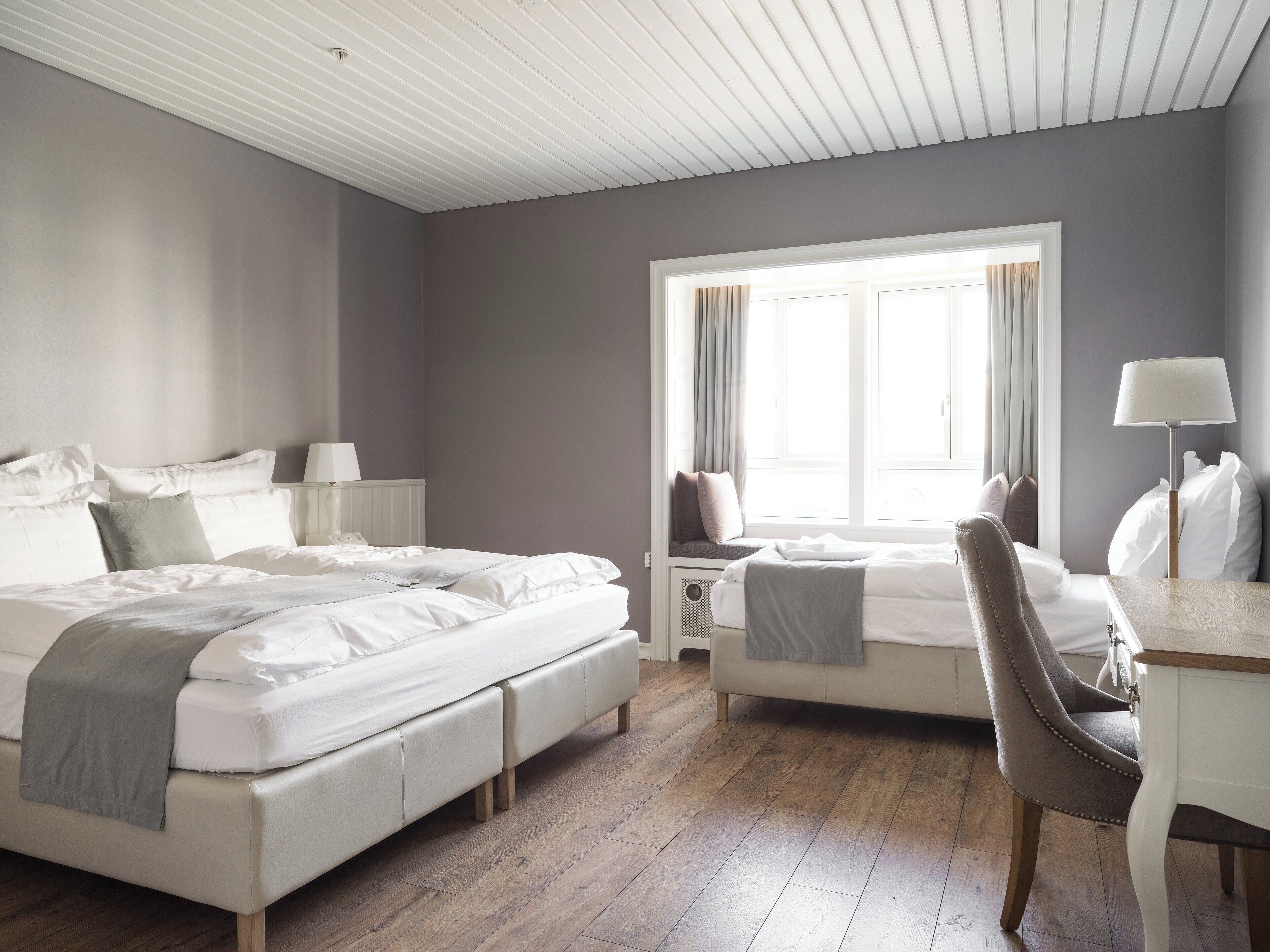 标准三人房 | 客房内保险箱、办公桌、笔记本电脑工作区、遮光窗帘