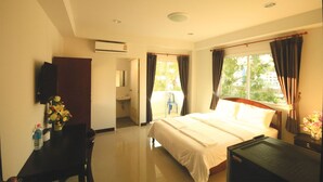 A hotel room with a bed, a desk, a chair, a sink, and a window with curtains. - Baan Samrarn (Krabi)