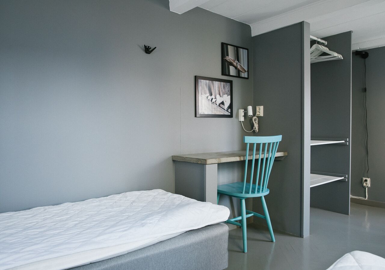 A modern bedroom with a bed, a desk, and a chair.