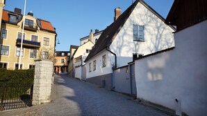 En kullerstensgata kantad av traditionella byggnader i europeisk stil, med balkonger och en blandning av olika arkitektoniska stilar.