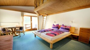 A cozy bedroom with a wooden bed, a desk, and a chair.