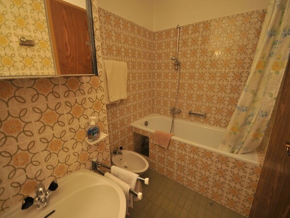 Un baño con lavamanos, espejo y ducha.