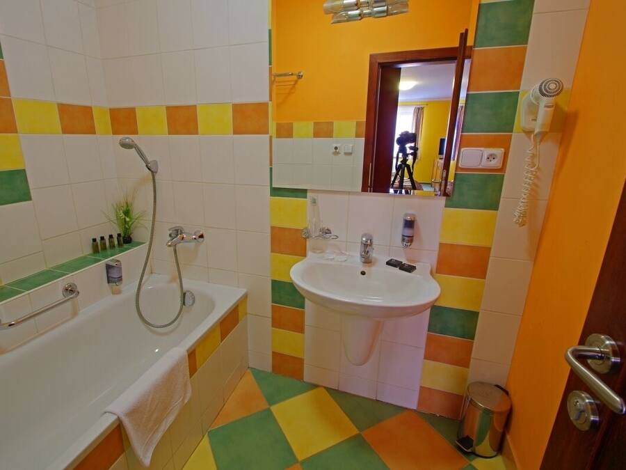 A bathroom with a bathtub, sink, and a mirror.