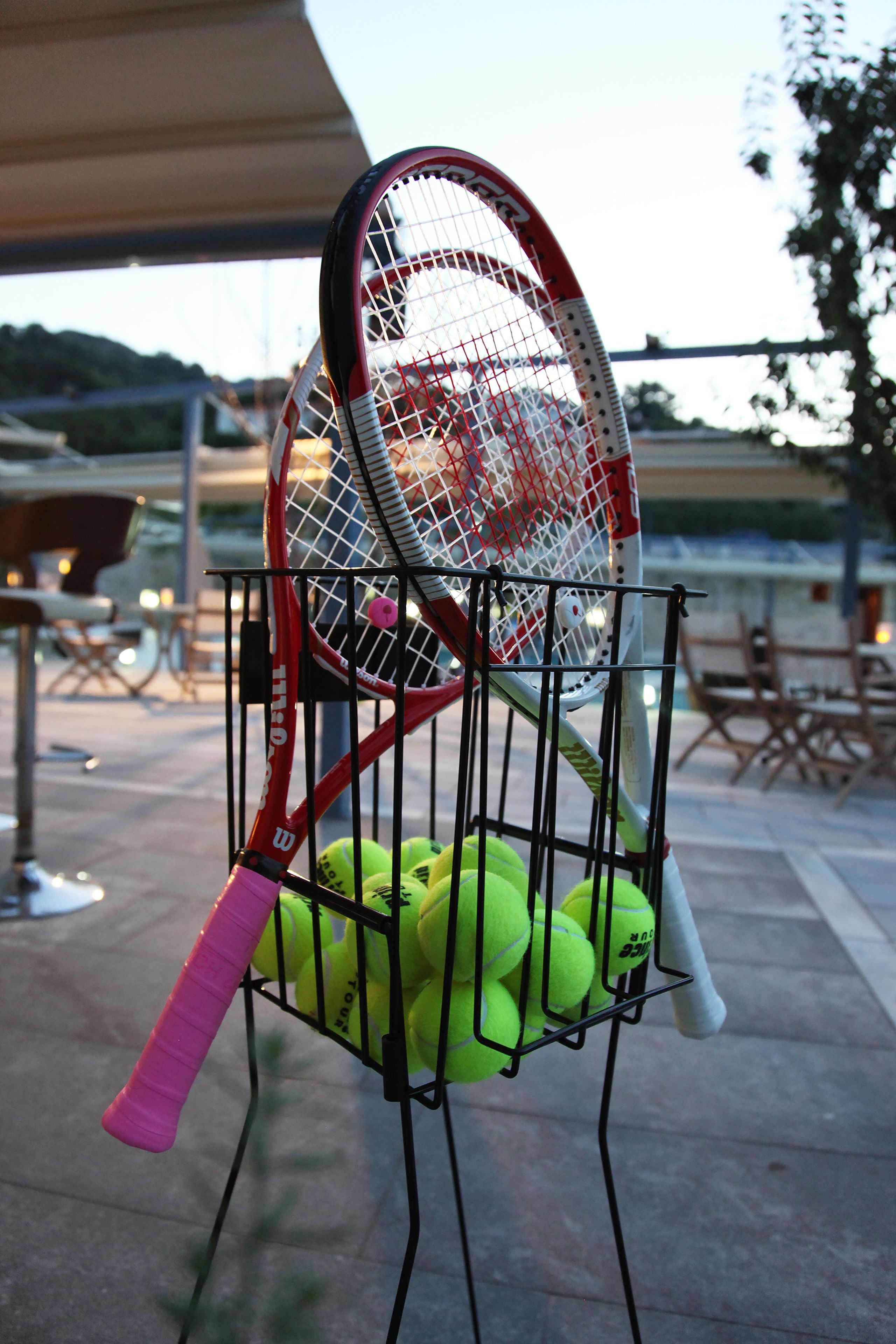 A tennis racket rack holding multiple tennis balls.