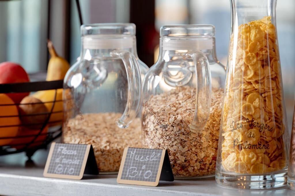 Tres frascos de vidrio llenos de diferentes tipos de granos y cereales, con etiquetas que indican que son orgánicos.