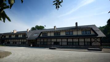 A traditional building with a tiled roof and a brick facade, featuring a large open courtyard.
