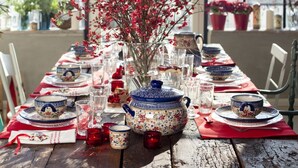 A wooden table set with blue and white floral-patterned tableware, red napkins, and clear glasses. - Folwark Książęcy (Osiecznica)
