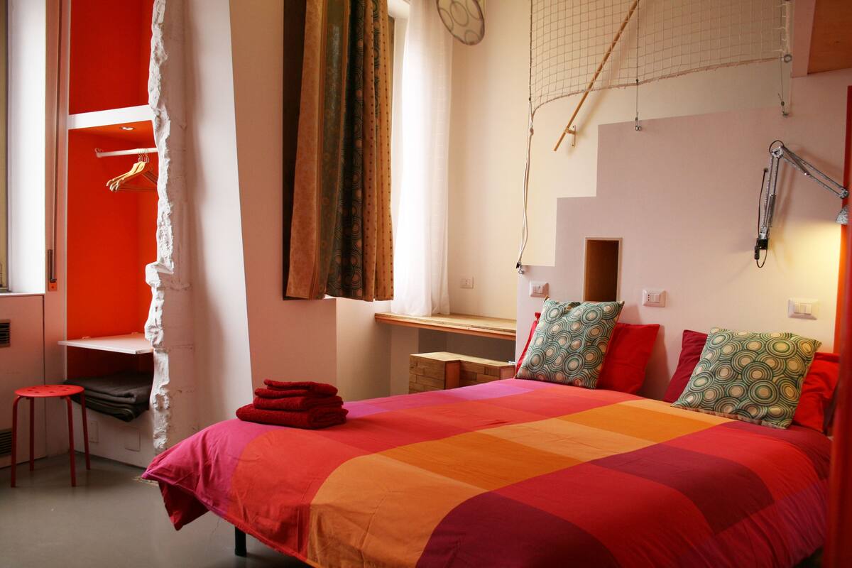 A bedroom with a bed, a desk, and a chair.