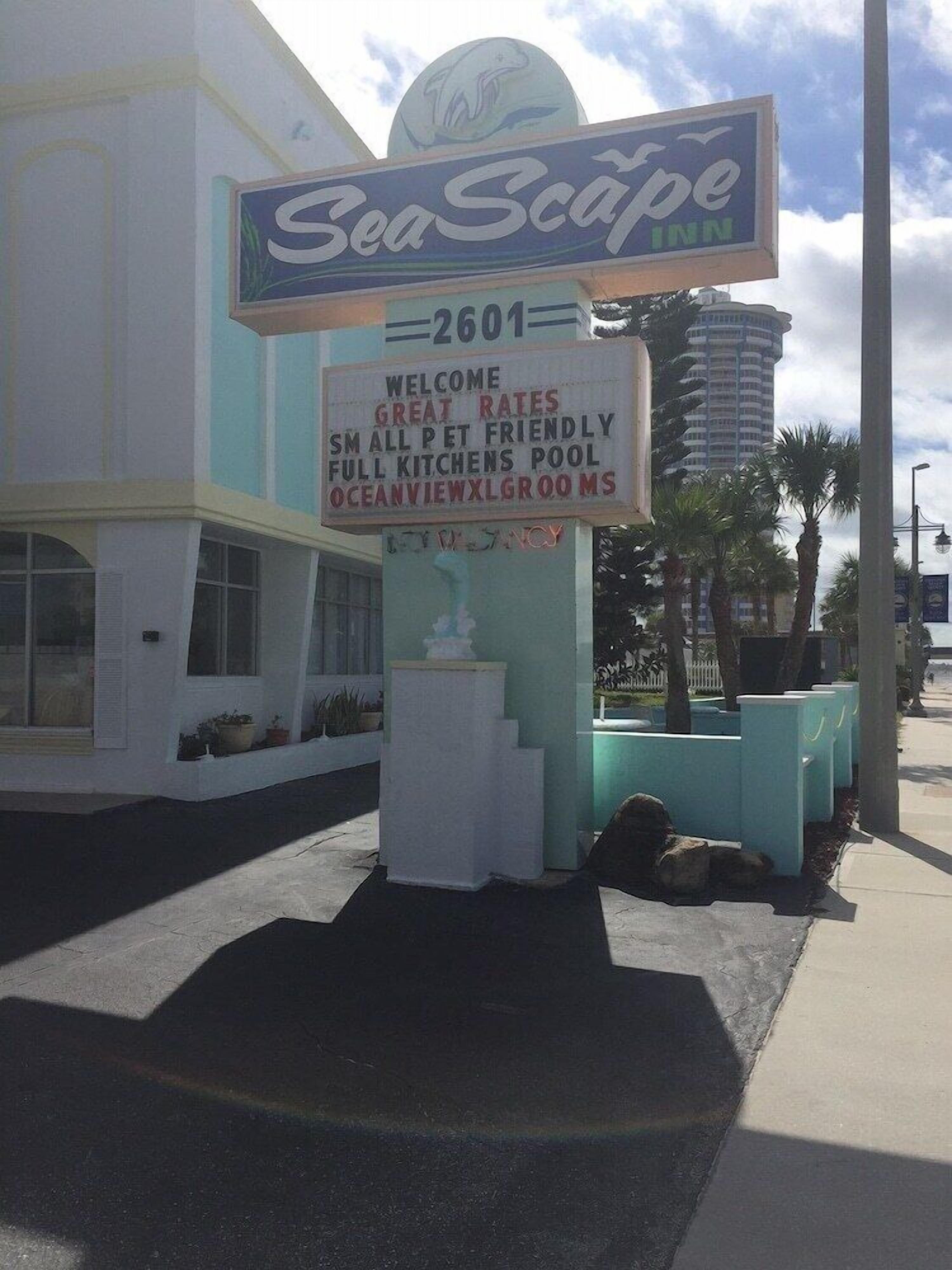Segnaletica del SeaScape Inn con servizi indicati, tra cui tariffe vantaggiose, accettazione di animali domestici di piccola taglia, cucine complete, piscina e vista sull'oceano.