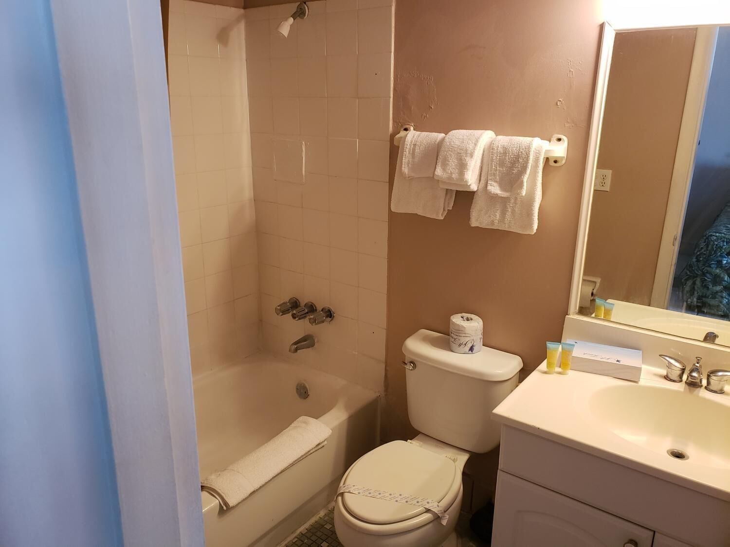 Un baño con bañera, inodoro, lavamanos y espejo.