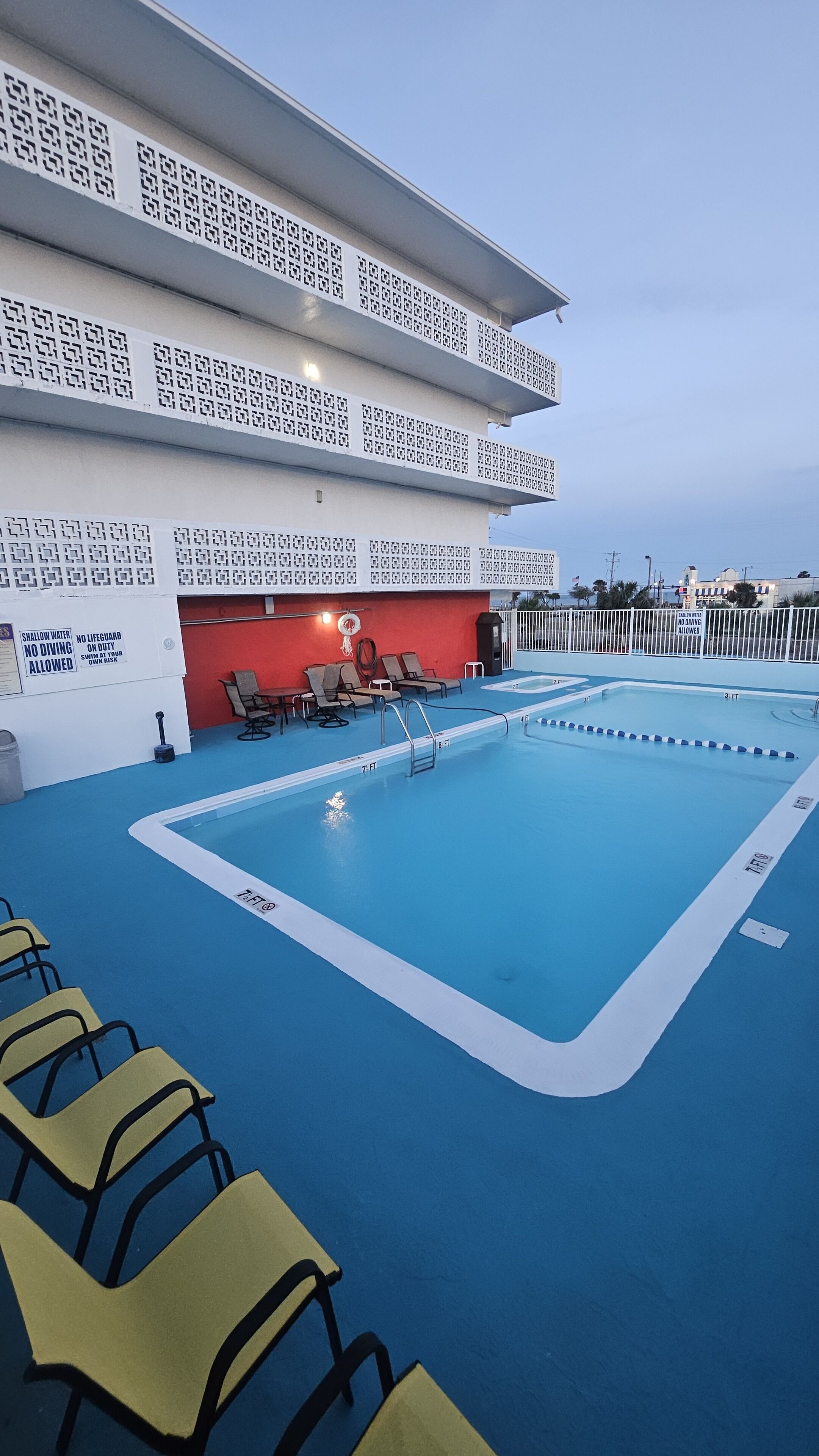 A pool area with lounge chairs and a lifeguard station.