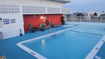 A pool area with lounge chairs and a lifeguard station.