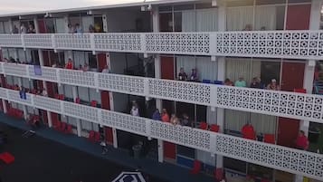 Un hotel de varios pisos con balcones, cada uno con barandilla decorada.