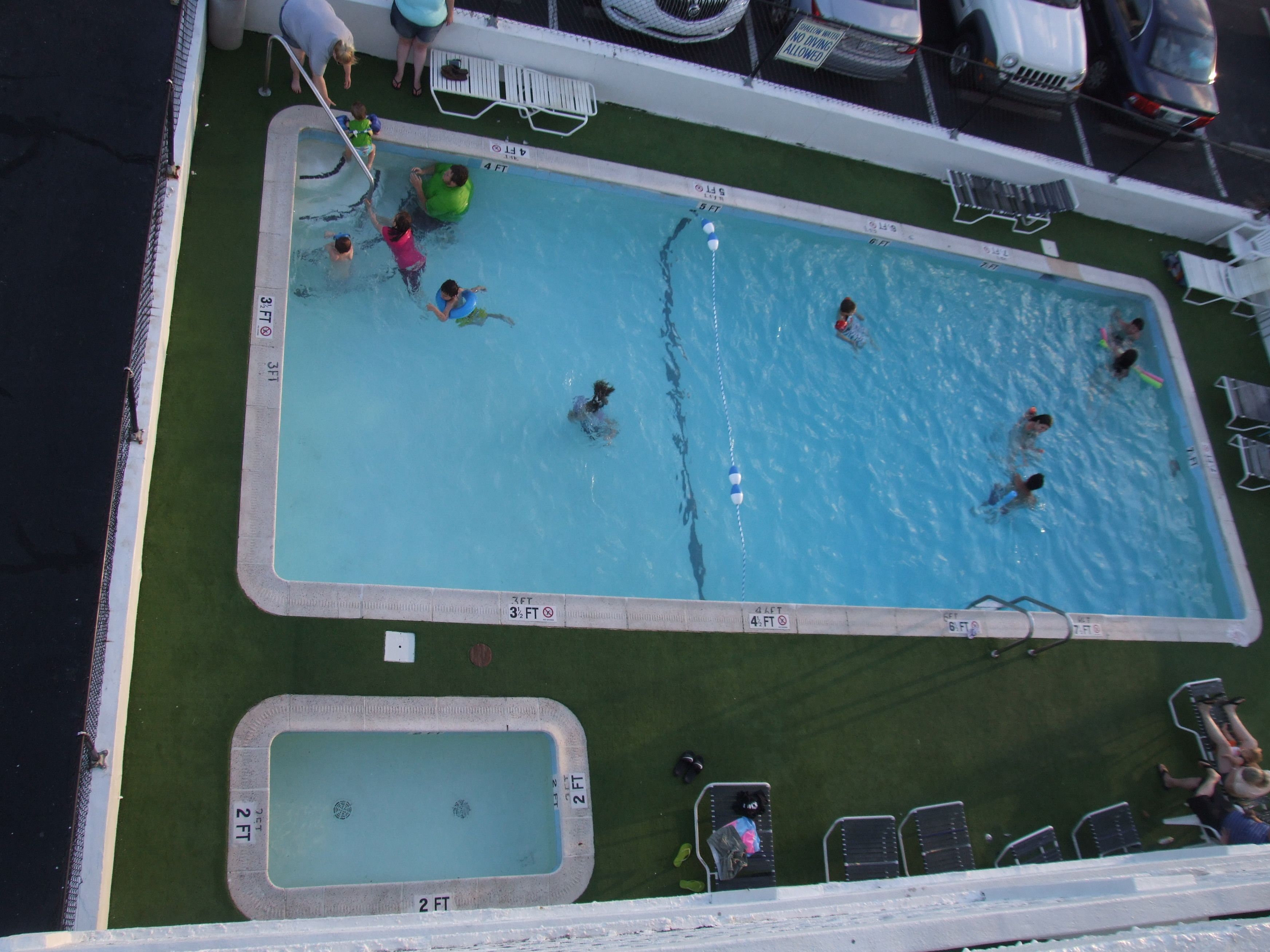 A pool area with multiple swimming pools, including a smaller one and a larger one with a diving board.