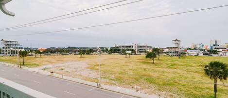 A view of a cityscape with buildings, a road, and a grassy area.
