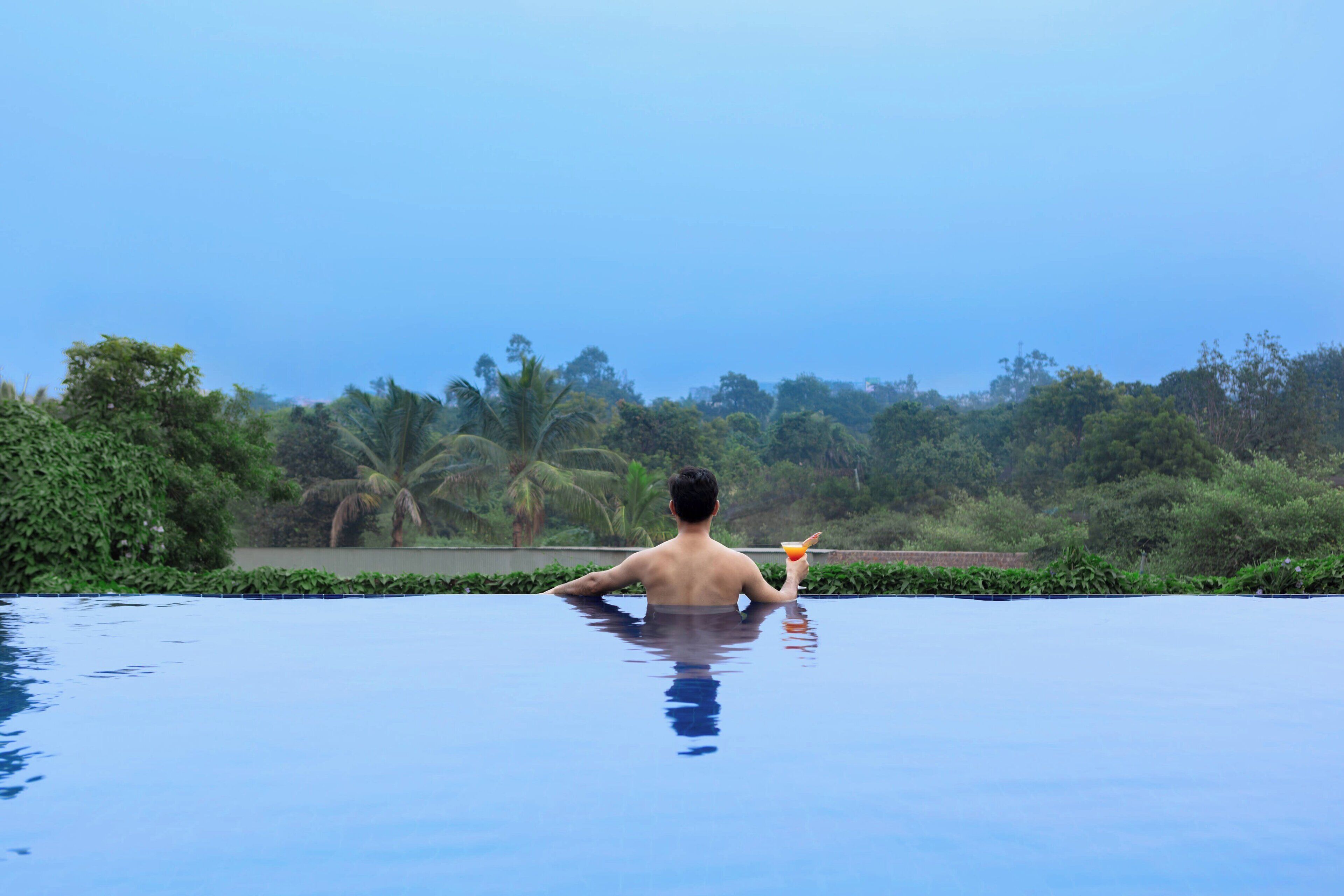 Una piscina al aire libre, sillones reclinables de piscina